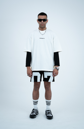 Model in the Haresquare White T-shirt with a Black print, styled with Haresquare Black shorts and designer sunglasses – unisex luxury sportswear from Ireland.